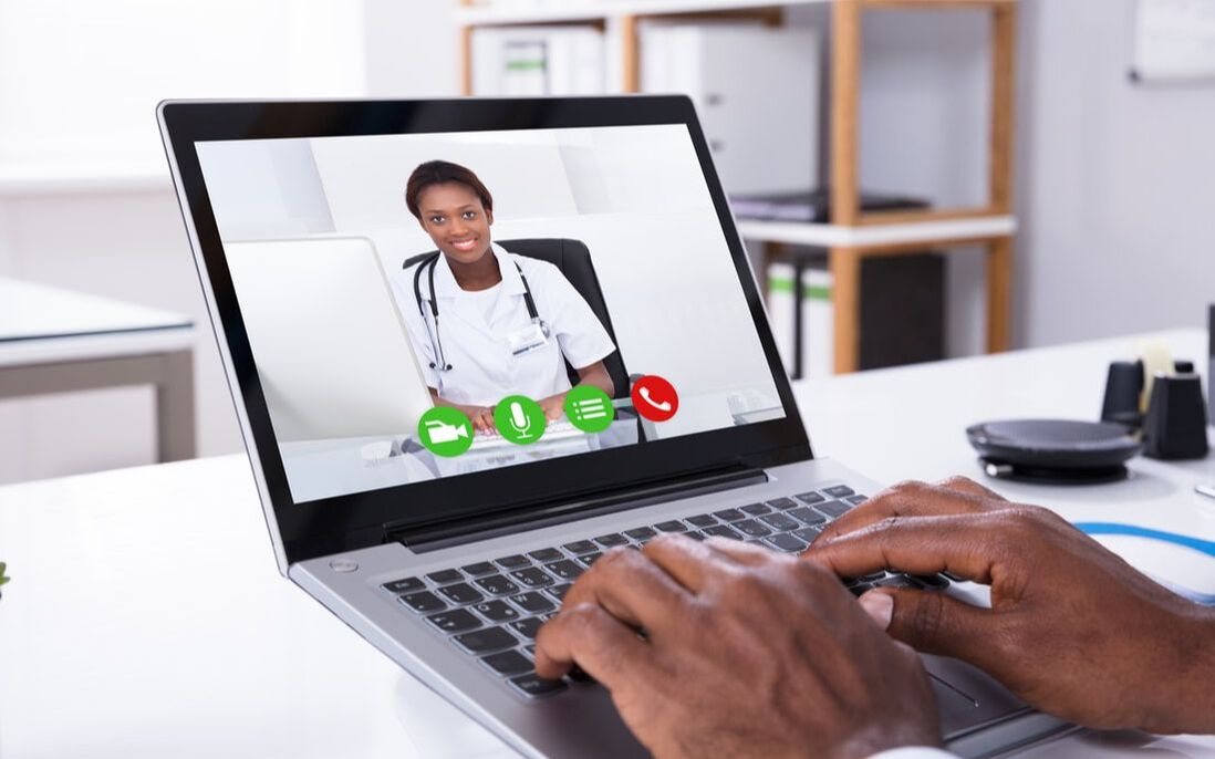 Person Video Conferencing With Female Doctor Through Laptop 